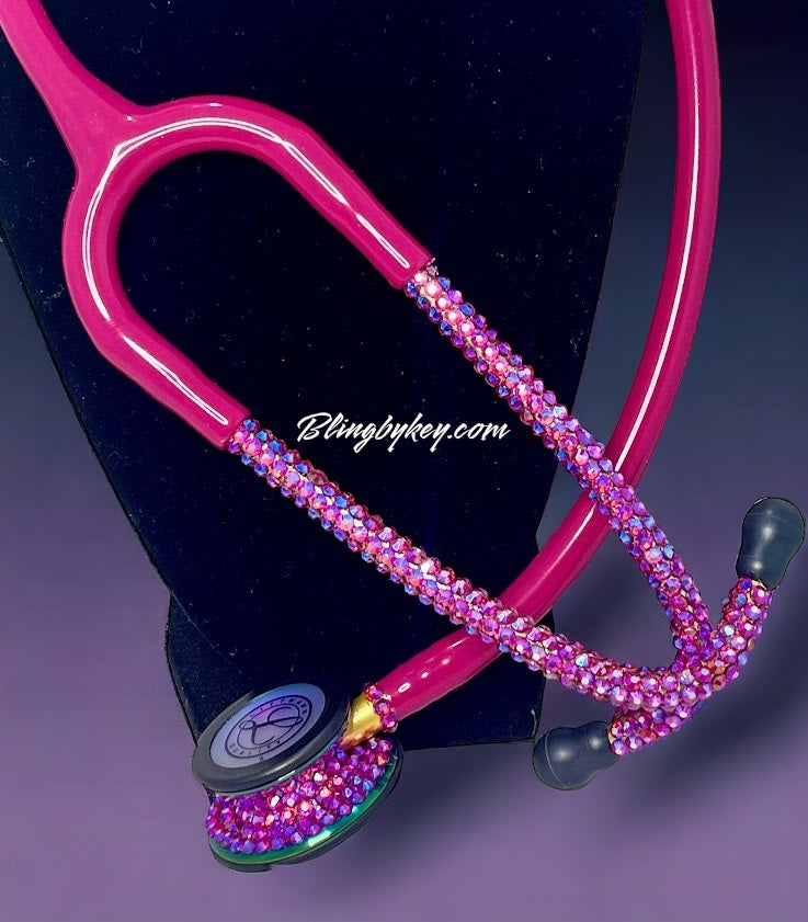 Pink stethoscope with gemstones on a dark background