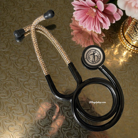 Decorative stethoscope with embellishments on a reflective surface with flowers in the background