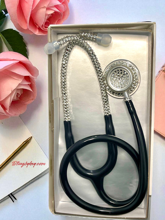 MDF Acoustica Black stethoscope, clear rhinestones  in a box with pink flowers and a pen on a white background