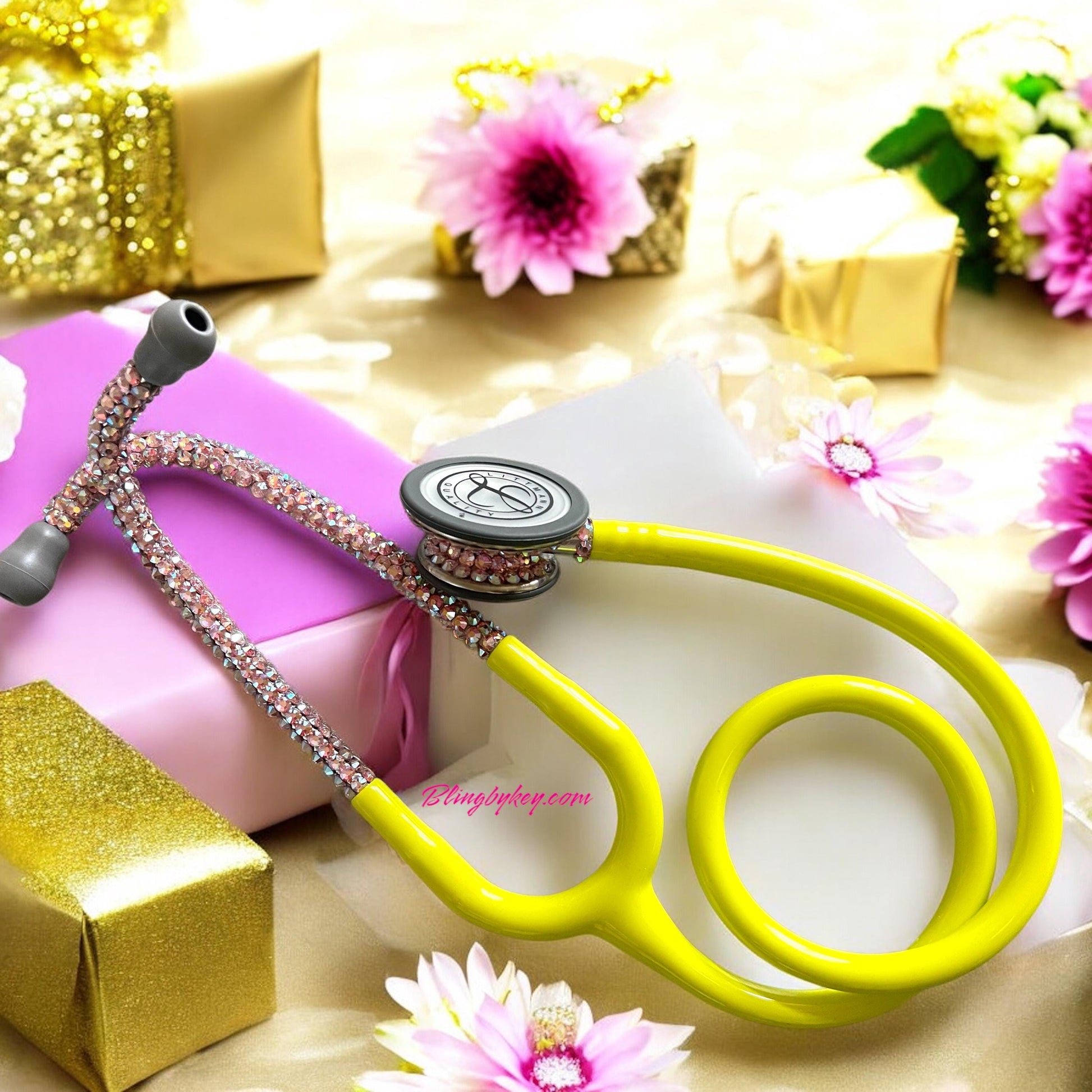 Introducing the "Ray of Sunshine" Littmann Stethoscope, a meticulously crafted instrument developed by Blingbykey specifically for healthcare professionals seeking to enhance their work environment with a touch of elegance. This medical device showcases a vivid Lemon Lime yellow finish, adorned with precisely hand-placed pink Preciosa crystals on both the headset and chest piece. This combination of functionality and aesthetic appeal is designed to promote positivity in all settings.