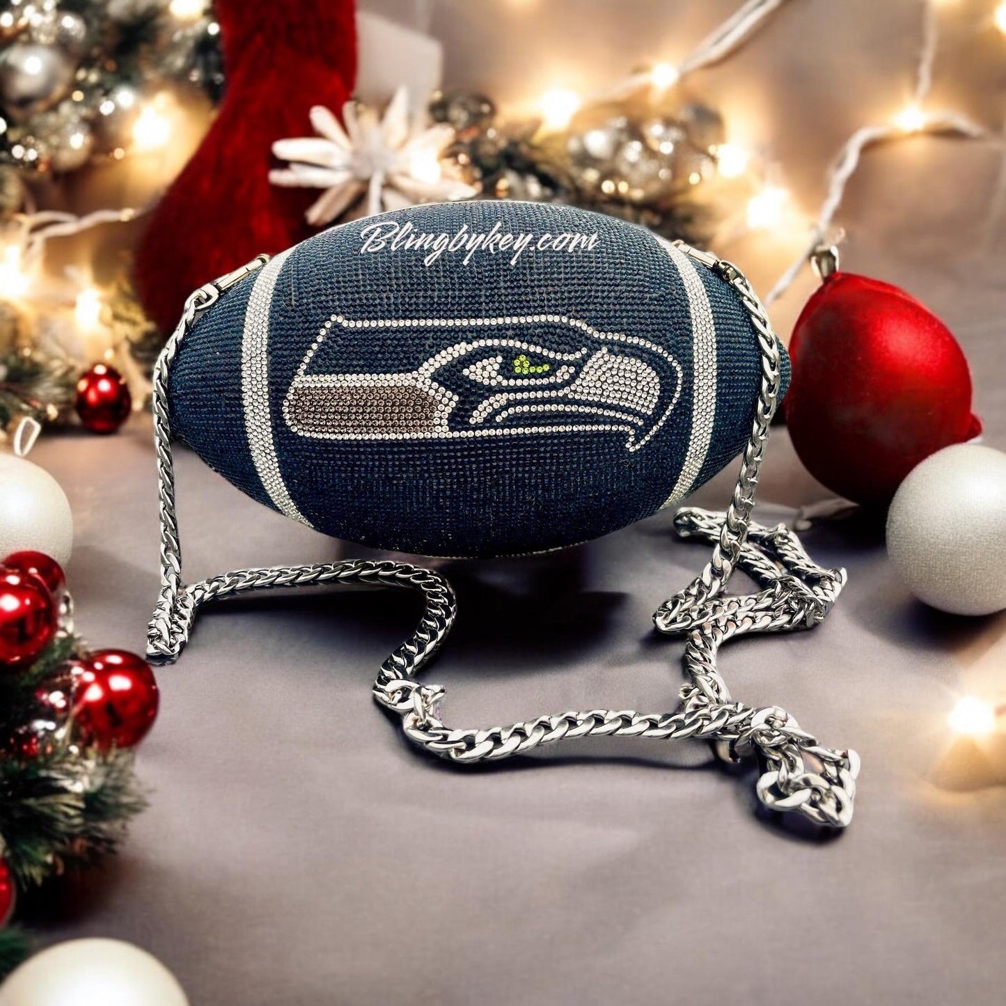 Seahawks Football Purse- designed with rhinestone adhesive on a football shaped handbag. Versatile style comes with a rhinestone wrist strap and a long silver strap for crossbody wear. Also makes a great collection for room decor with straps removed.